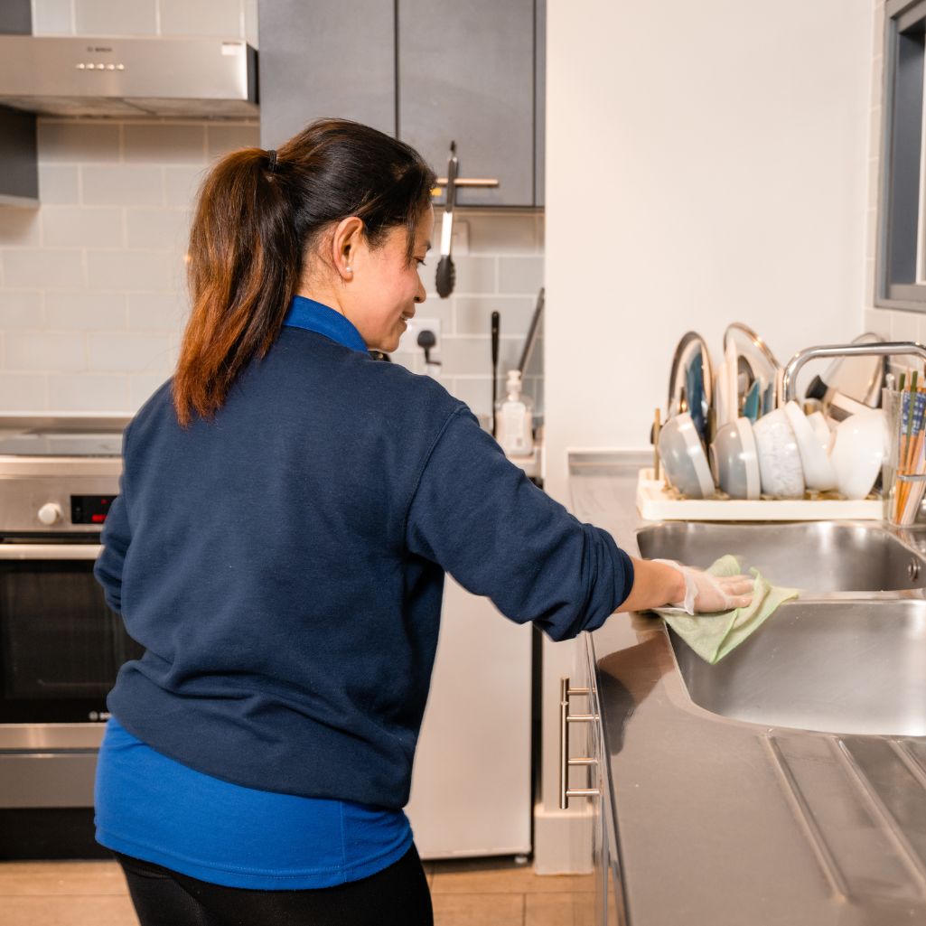 Image of female employee cleaning kitchen
