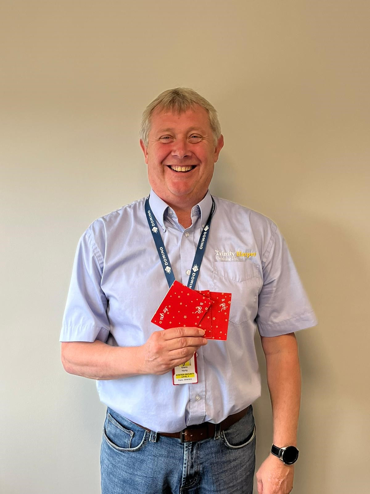 Man stood in front of a wall holding cards