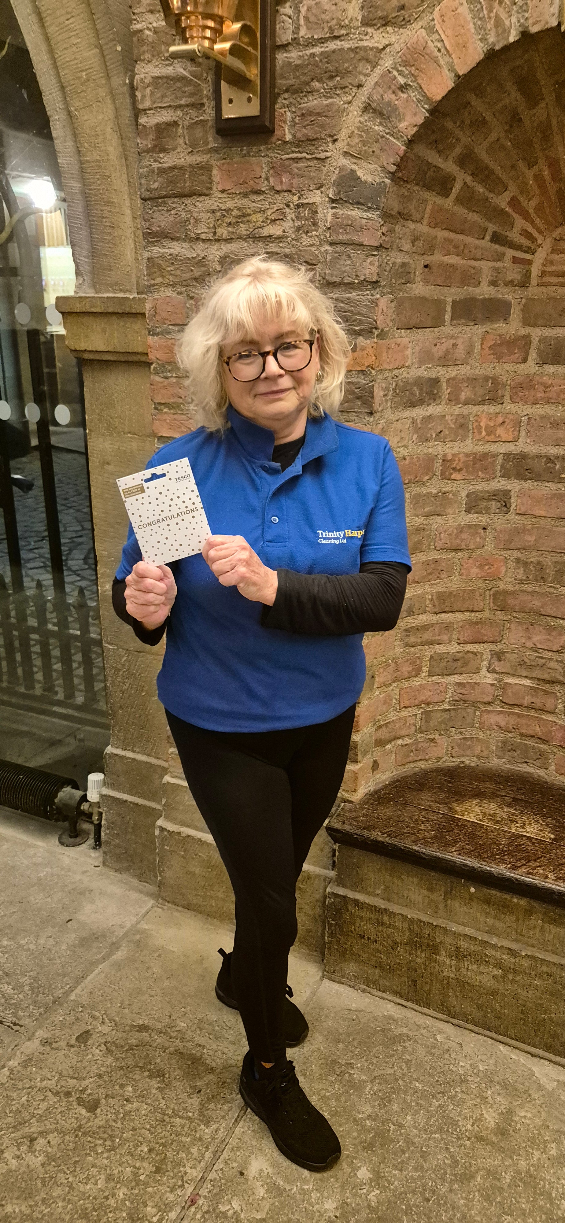 Lady in a blue shirt holding a gift card
