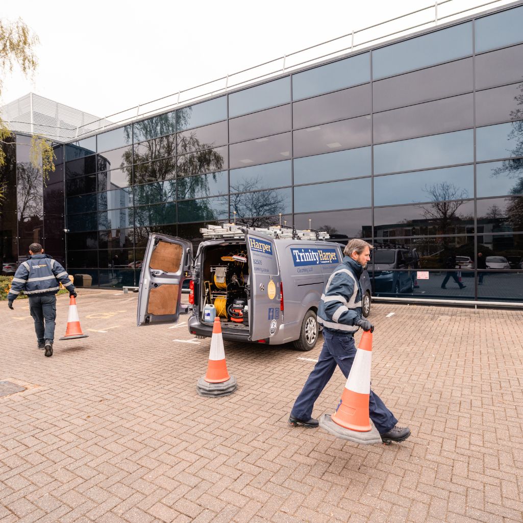 Image of cleaners setting out cones for external building cleaning