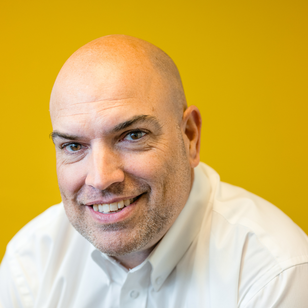 Close-up of man in a white shirt with a yellow background