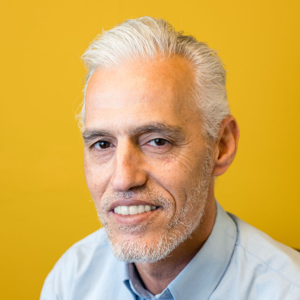 Close-up of  man with grey hair on a yellow background